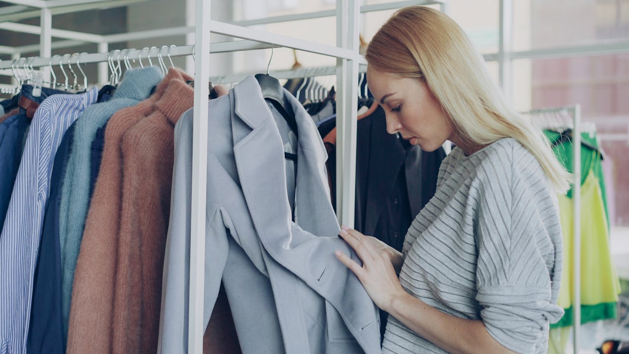 A woman browsing clothing racks in a stylish boutique.